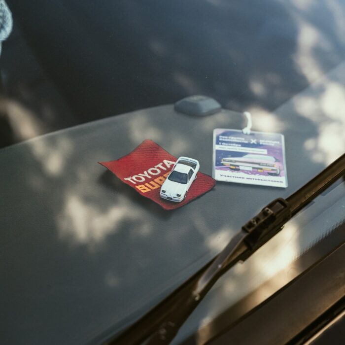 a car with a parking ticket and a cell phone on the windshield