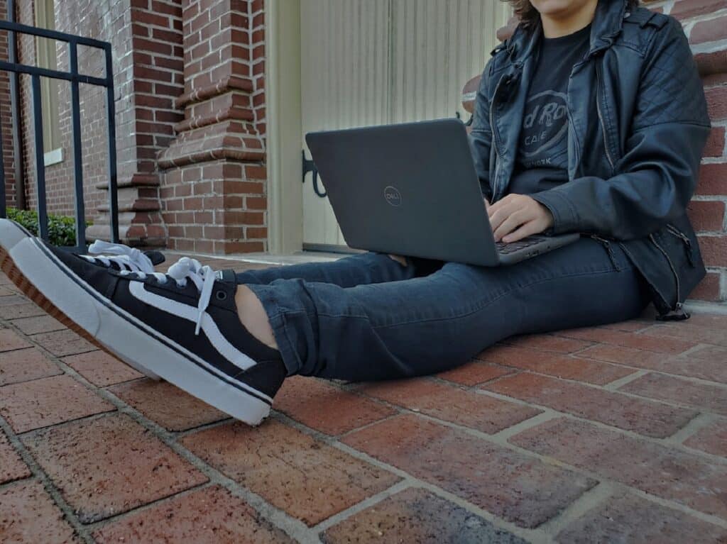 a person sitting on the ground with a laptop