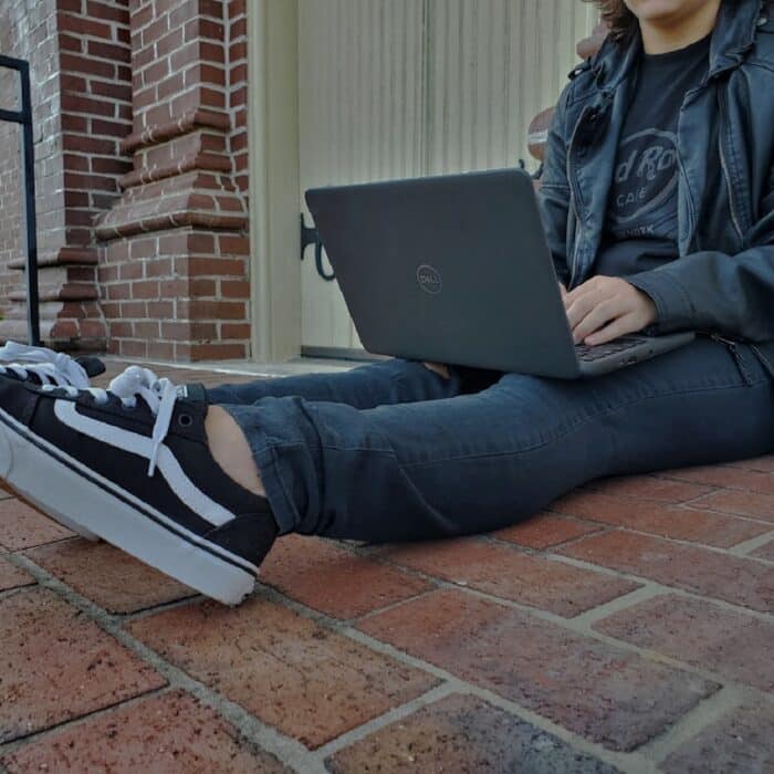 a person sitting on the ground with a laptop