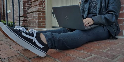 a person sitting on the ground with a laptop