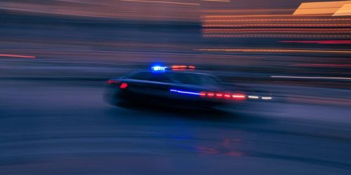 a police car driving down a street at night